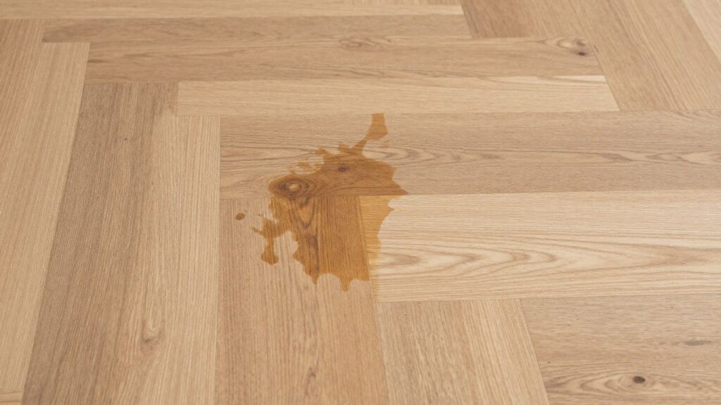 Water-damaged hardwood floor next to a repaired section.
